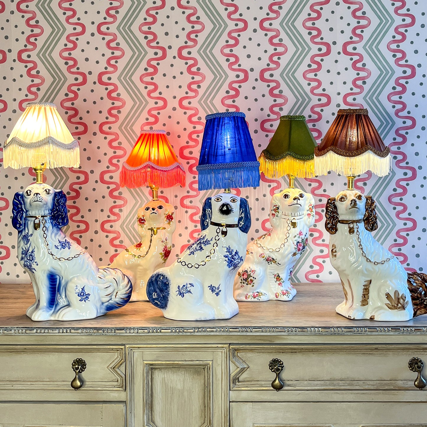 Pair of floral Staffordshire dog lamps with coral shades