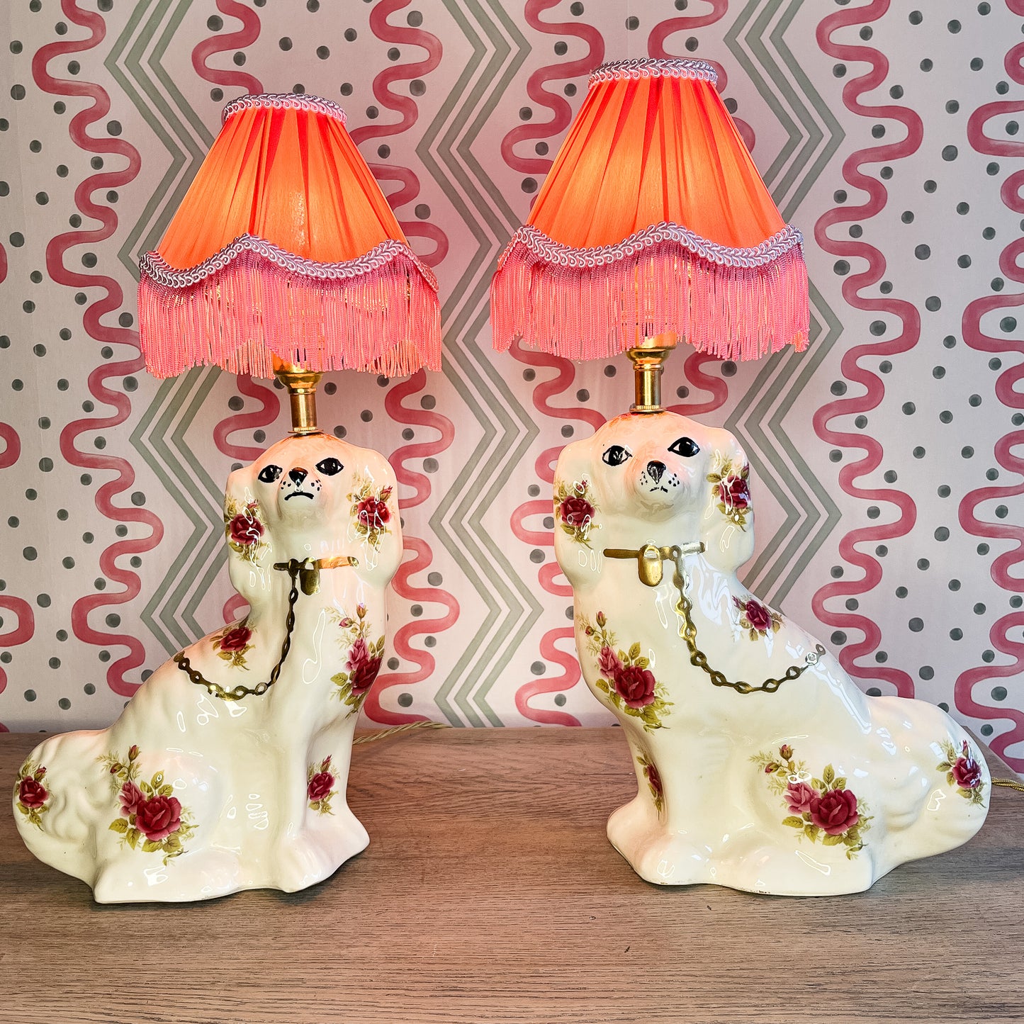 Pair of floral Staffordshire dog lamps with coral shades