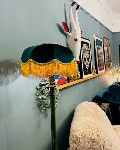 Emerald velvet fringed floor lamp shade in a blue living room