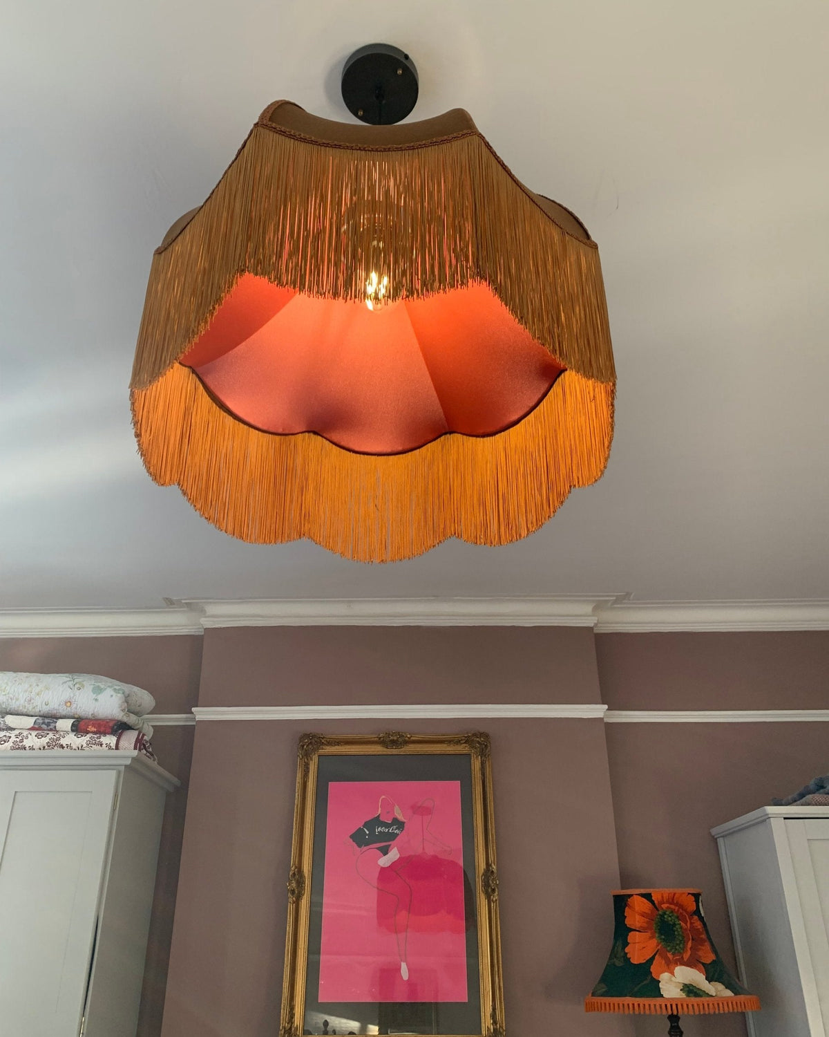 Fringed ceiling pendant with a glowing pink lining