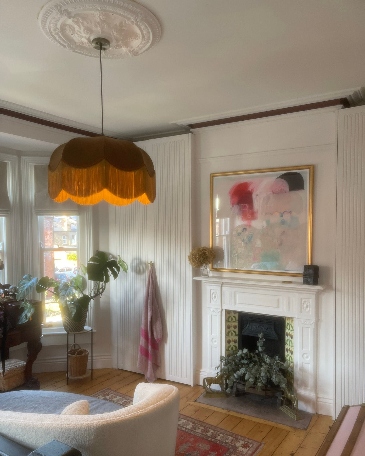 Ochre velvet fringed pendant shade in a white panelled room