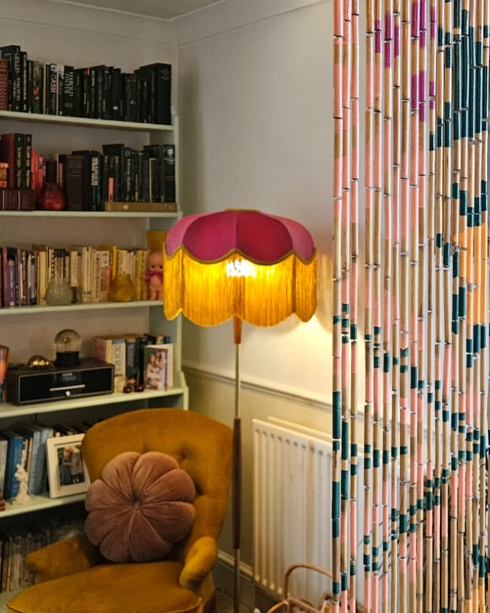 Pink and gold fringed floor lamp in a reading corner