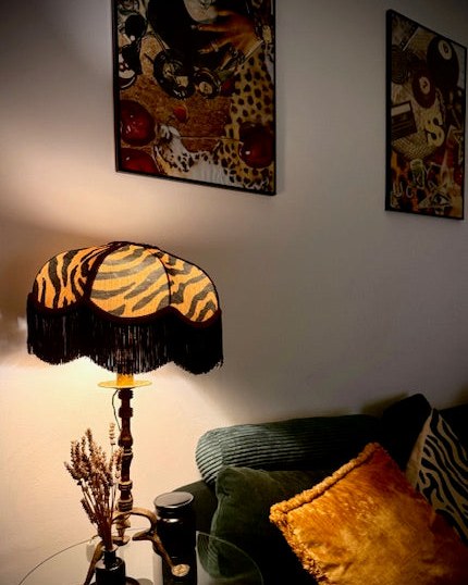 Tiger stripe fringed table lamp on a glass side table