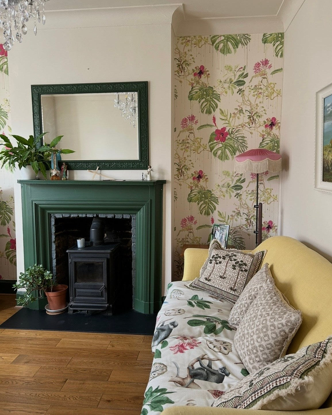 Living room with tropical wallpaper and a pink fringed floor lamp in the morning
