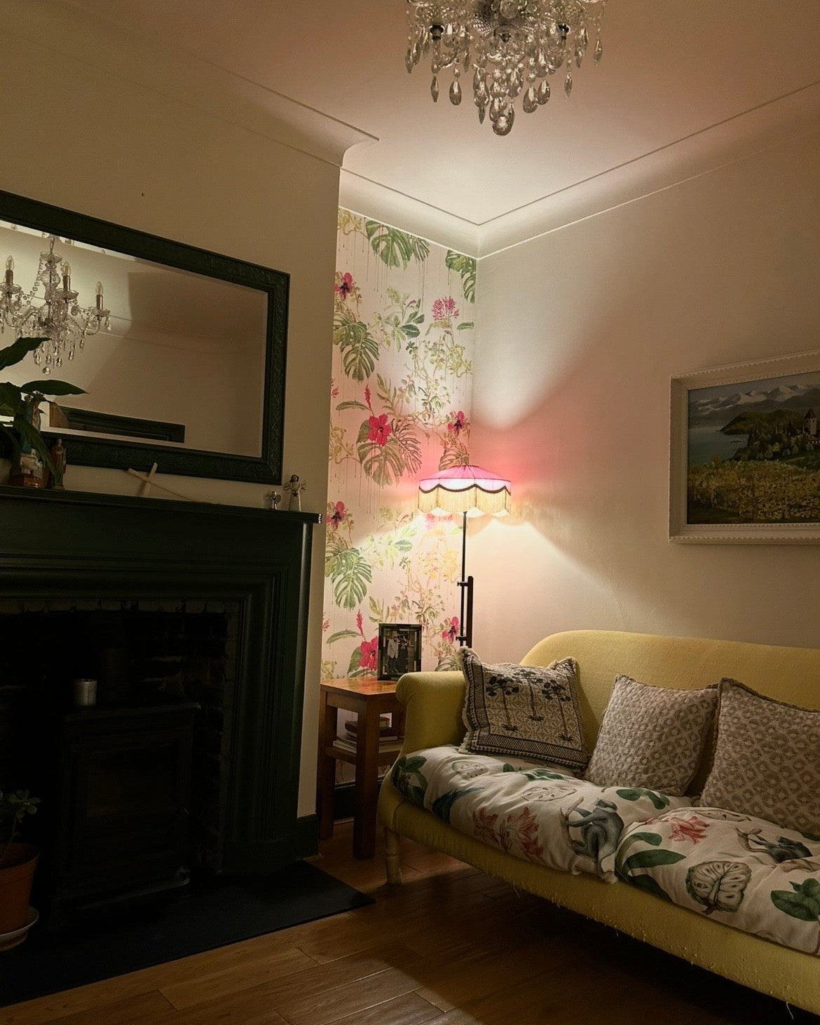 Pink fringed floor lamp lighting a living room in the evening