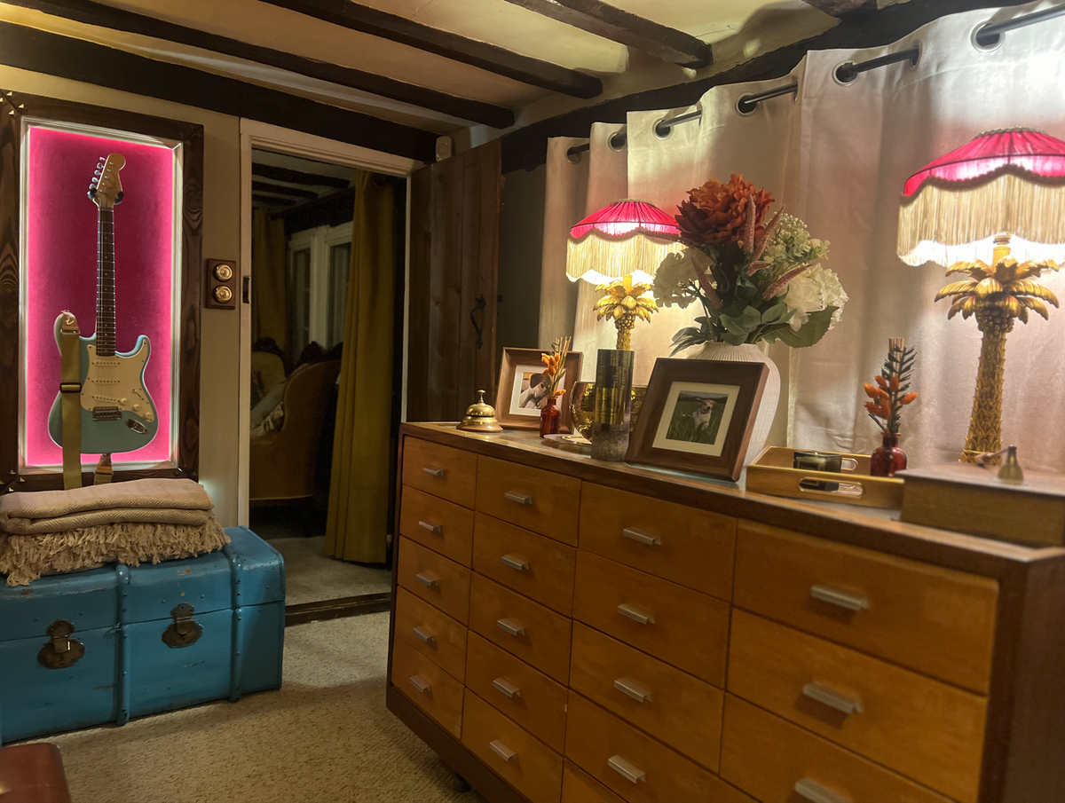 Pair of pink velvet fringed lampshades on gold palm lamps in a beamed cottage room